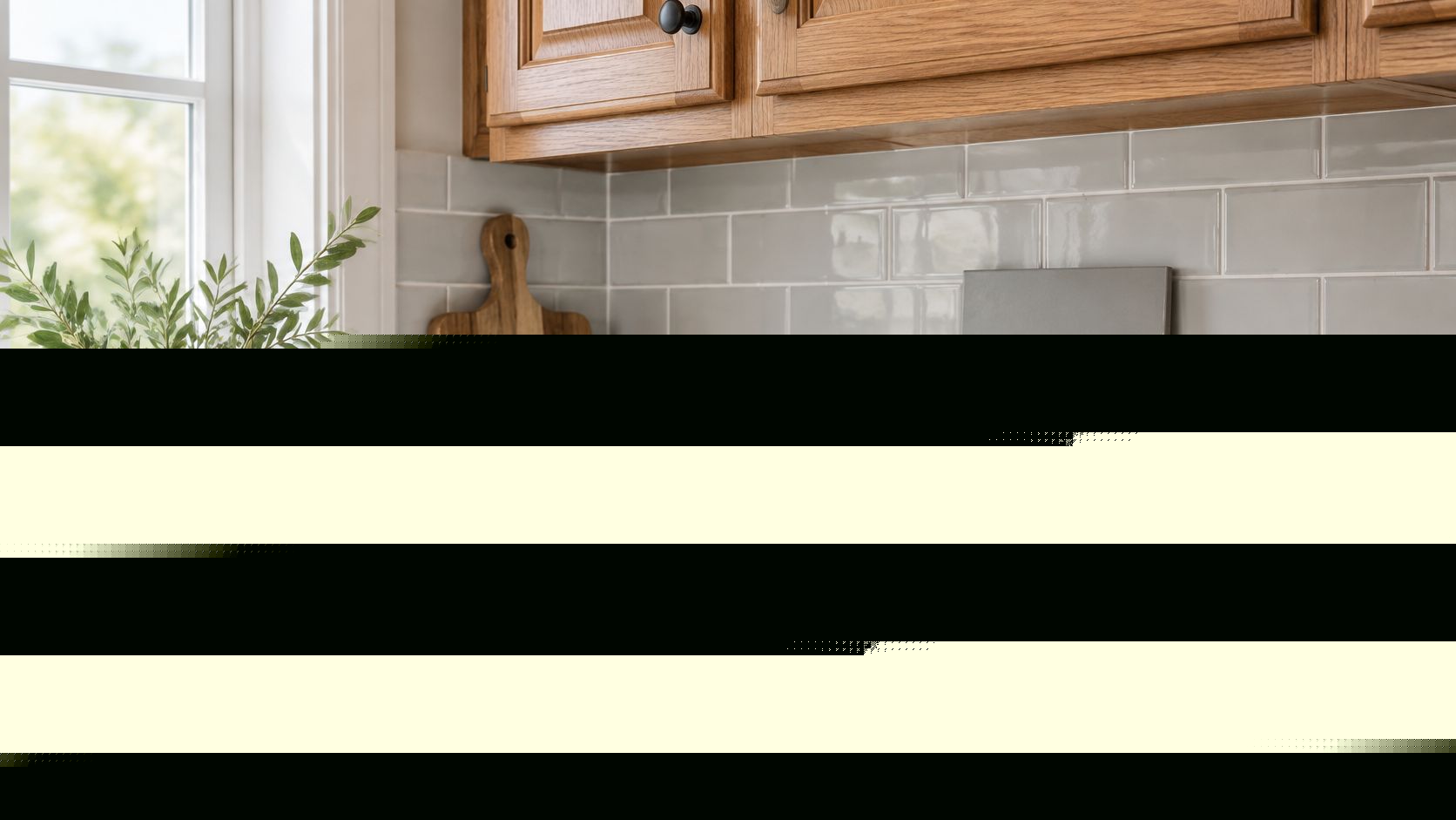 A hand holding a grey square tile against a light grey subway tile kitchen backsplash countertop background.