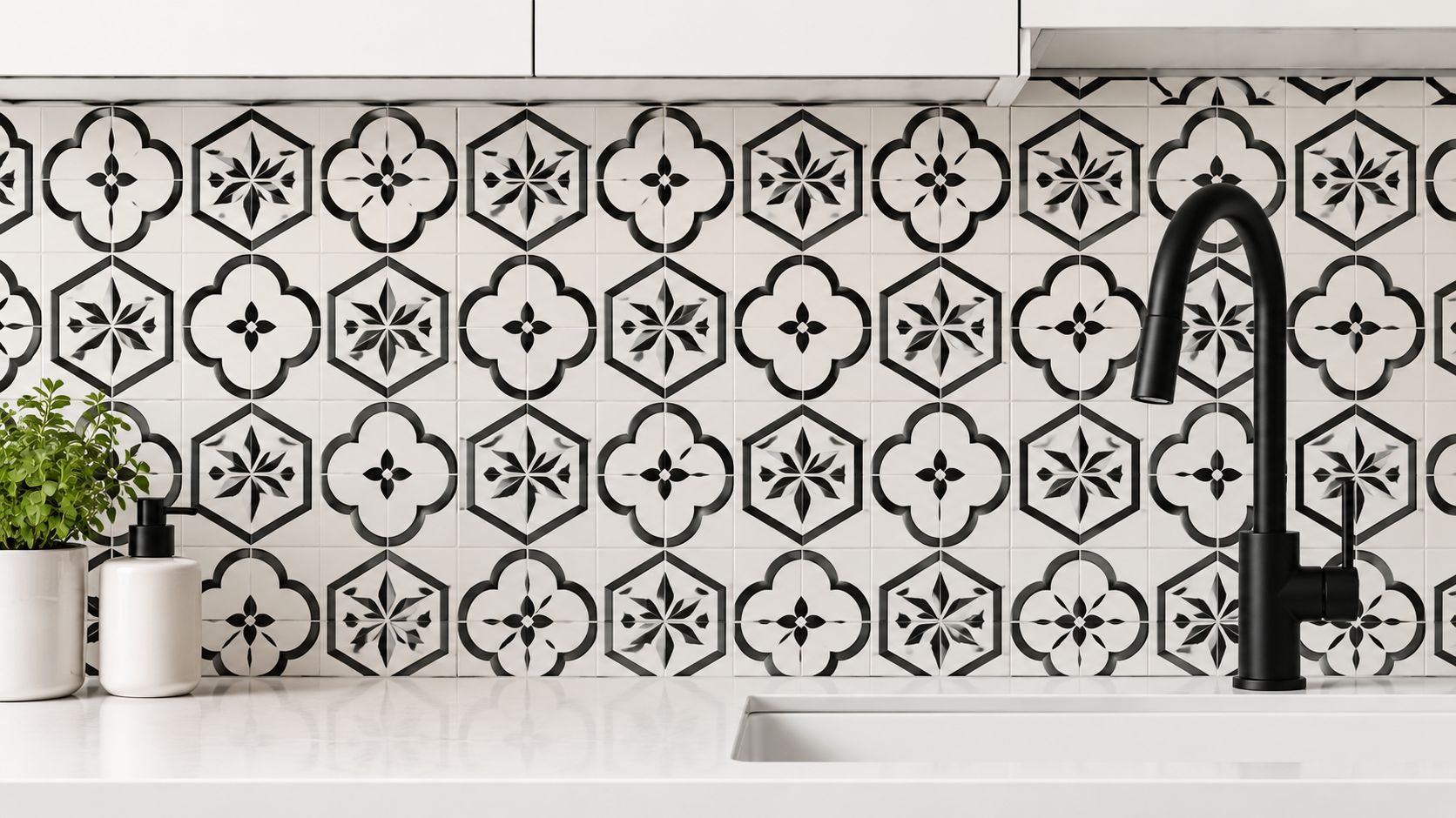 A modern kitchen backsplash featuring intricate black and white patterned tiles with a black faucet and plant.